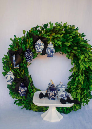 A green boxwood wreath with ginger jar ornaments.